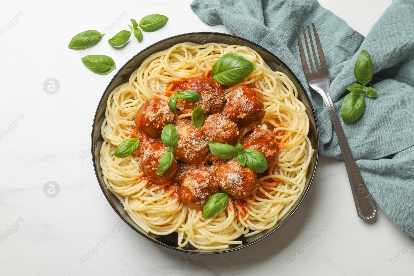 Photo of Delicious pasta with meatballs served on white marble table, flat lay