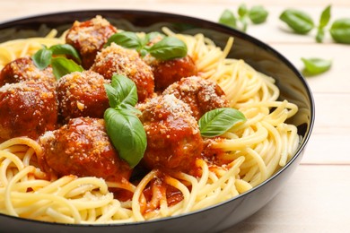 Delicious pasta with meatballs on wooden table, closeup