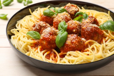 Photo of Delicious pasta with meatballs on wooden table, closeup