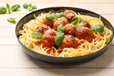 Photo of Delicious pasta with meatballs on wooden table, closeup