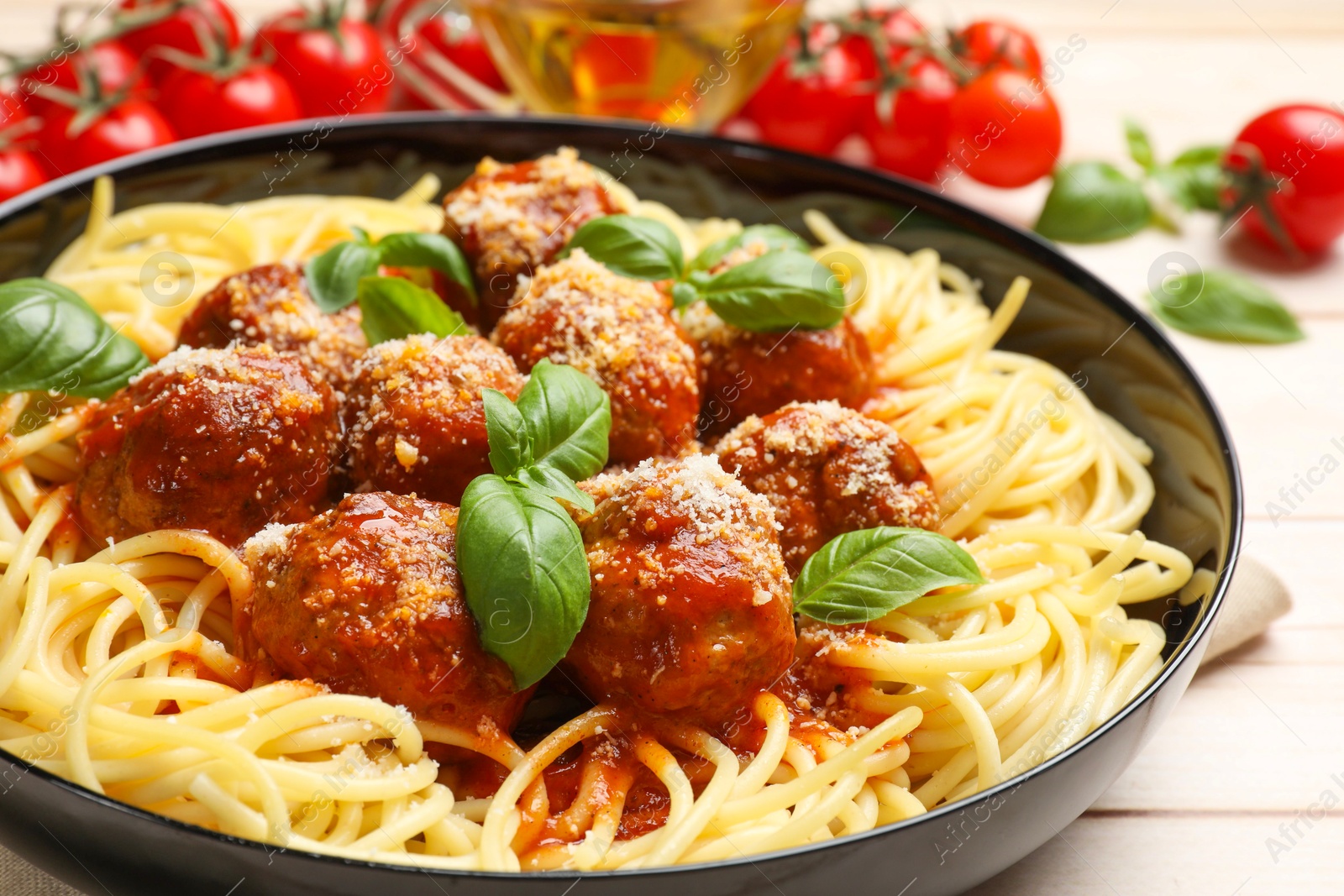 Photo of Delicious pasta with meatballs on wooden table, closeup