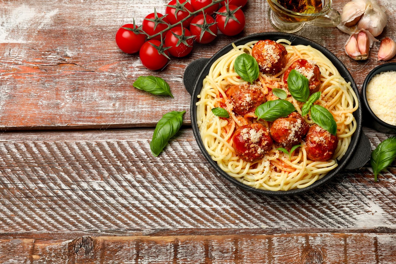 Photo of Delicious pasta with meatballs and ingredients on wooden table, flat lay. Space for text