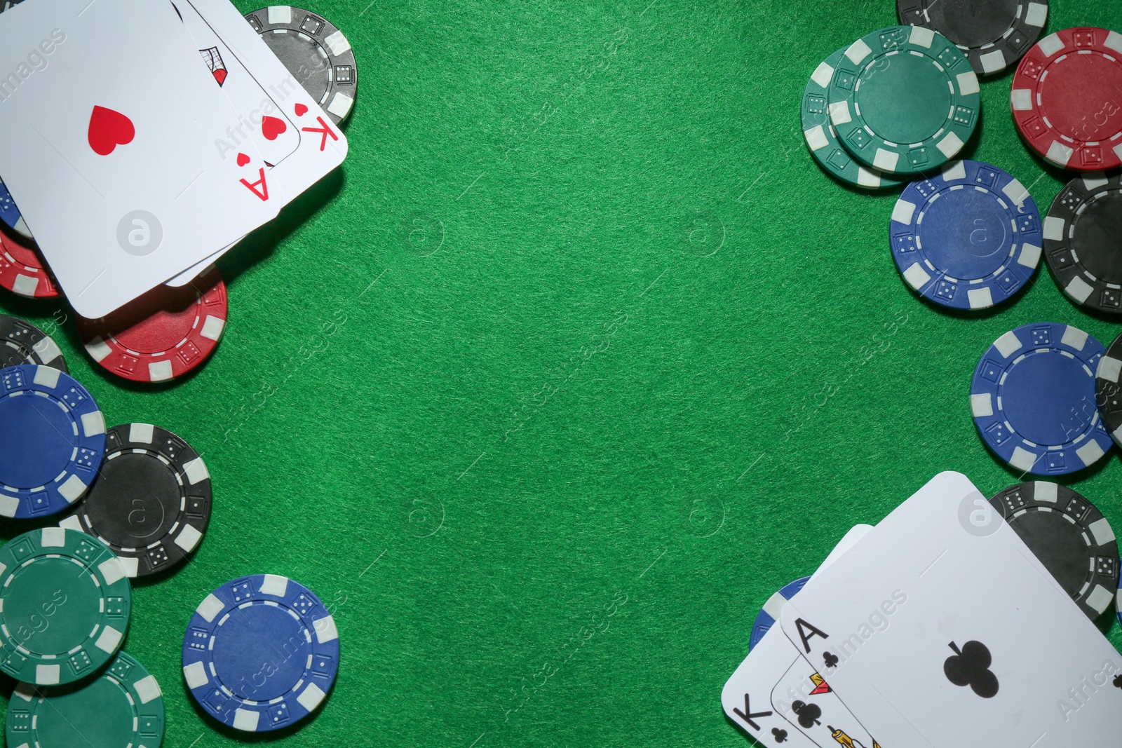 Photo of Frame of poker chips and playing cards on green table, flat lay. Space for text