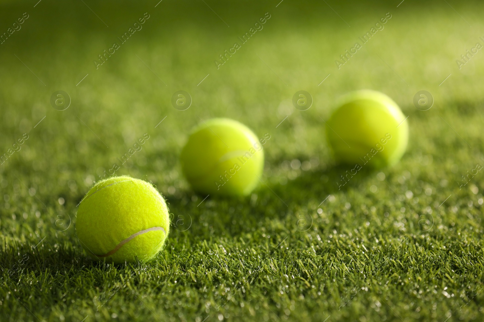 Photo of Many tennis balls on green artificial grass