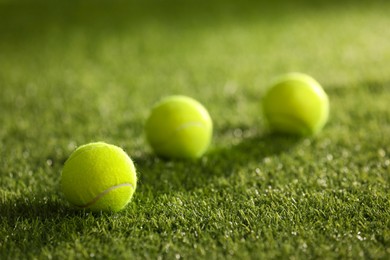 Photo of Many tennis balls on green artificial grass