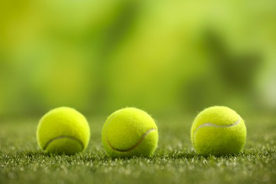 Photo of Tennis balls on green artificial grass, space for text