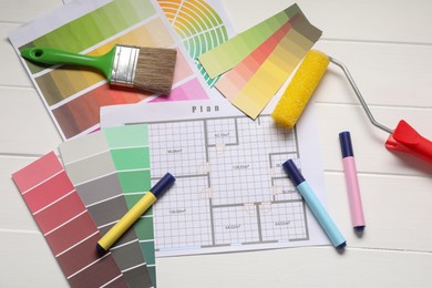 Photo of Designer's workplace with color palettes, floor plan and different supplies on white wooden table, flat lay