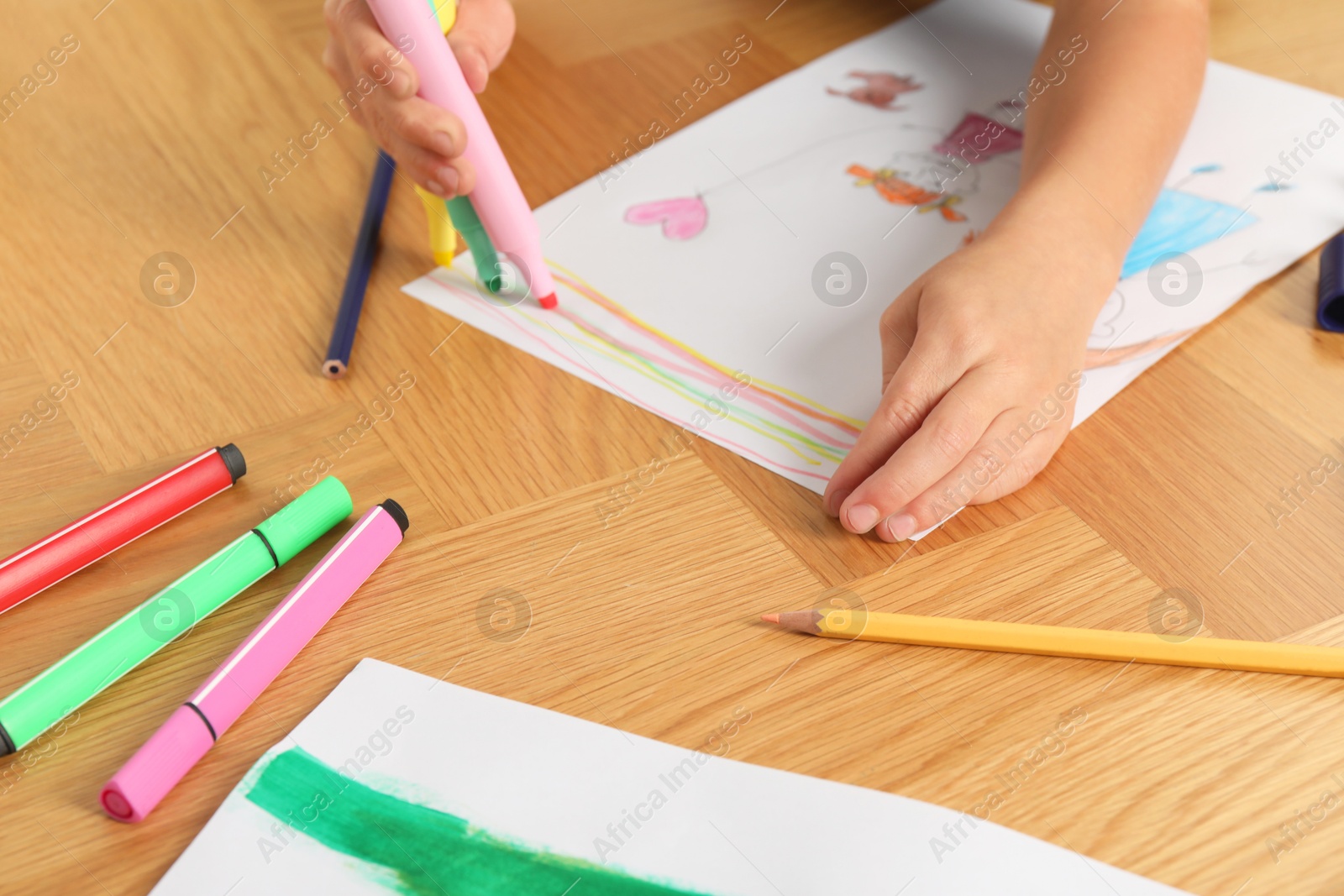 Photo of Boy drawing picture at wooden table, closeup