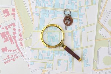 Photo of House hunting. Maps, magnifying glass and key on table, flat lay