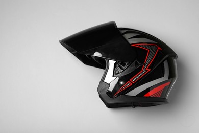 Photo of Modern motorcycle helmet with visor on gray background, top view. Space for text