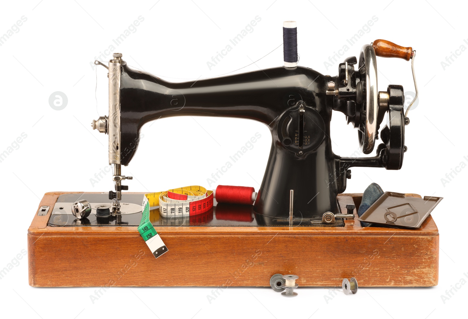 Photo of Sewing machine with measuring tape and spools of threads isolated on white