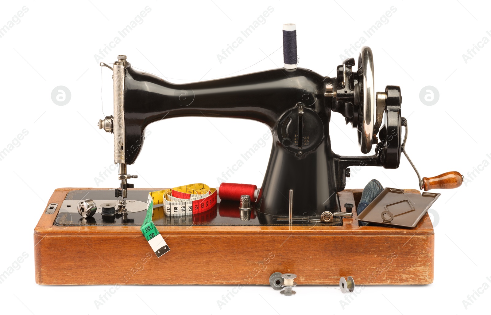 Photo of Sewing machine with measuring tape and spools of threads isolated on white