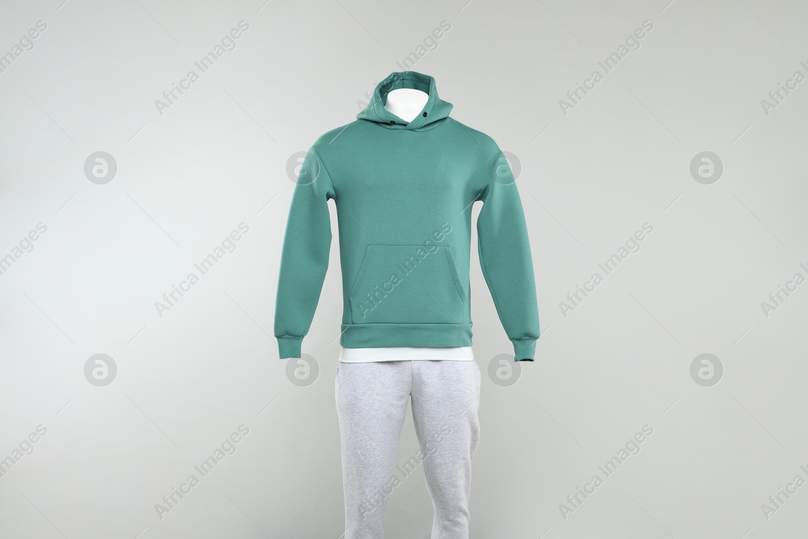 Photo of Male mannequin with stylish hoodie and sweatpants on light background