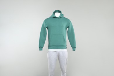 Photo of Male mannequin with stylish hoodie and sweatpants on light background