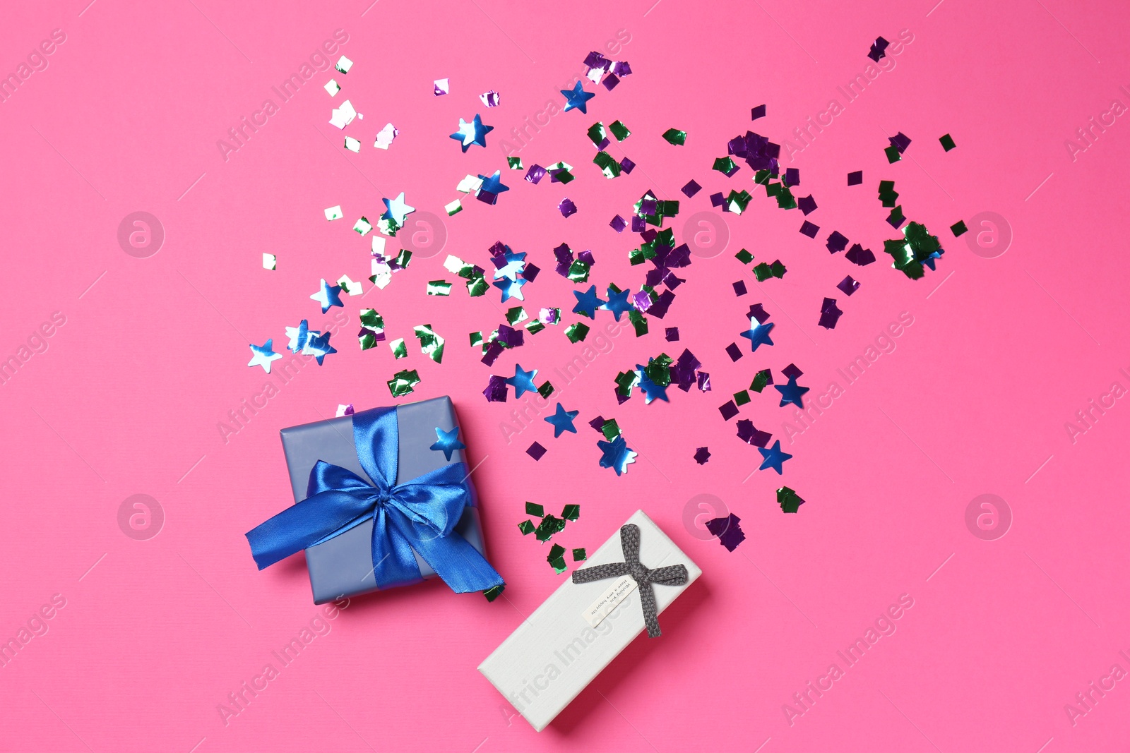 Photo of Shiny confetti and gift boxes on bright pink background, flat lay