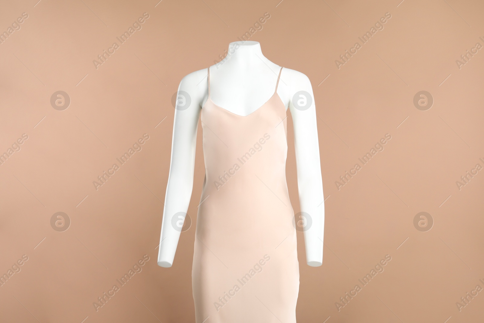 Photo of Female mannequin with stylish dress on light brown background