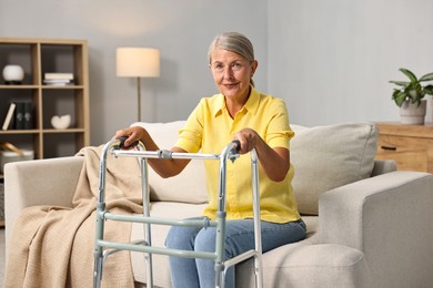 Photo of Senior woman with walking frame on sofa at home