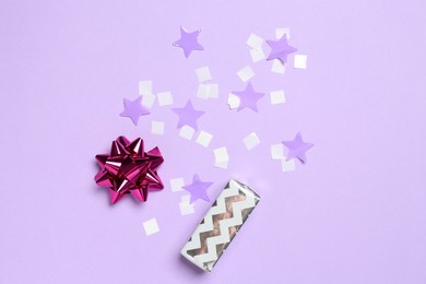 Shiny confetti and festive decor on violet background, flat lay