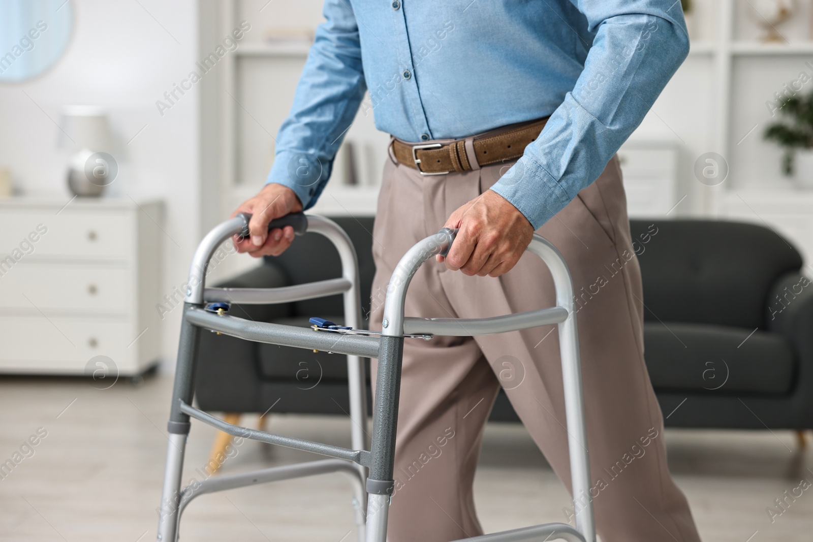 Photo of Senior man using walking frame at home, closeup