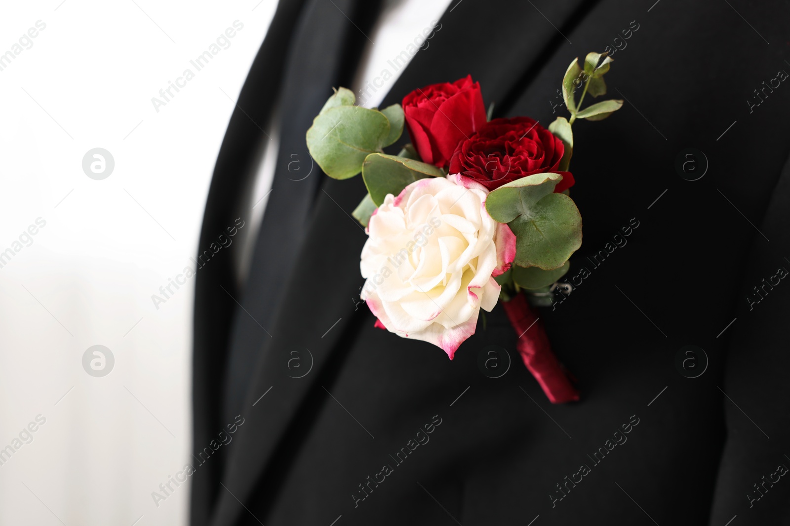 Photo of Groom in suit with stylish boutonniere indoors, closeup