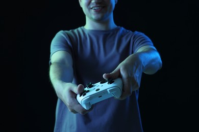 Man with controller on black background, closeup