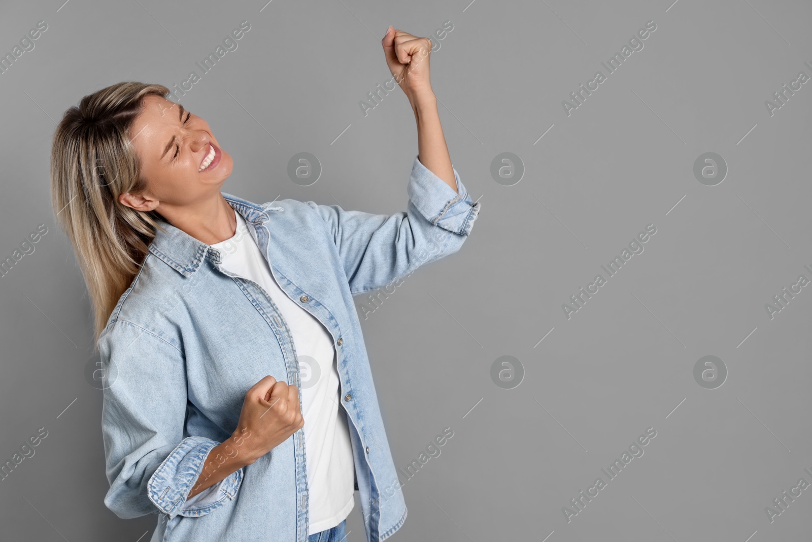 Photo of Happy winner on gray background, space for text