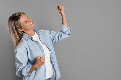 Photo of Happy winner on gray background, space for text