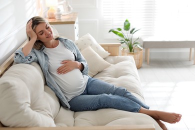 Photo of Portrait of beautiful pregnant woman on sofa at home