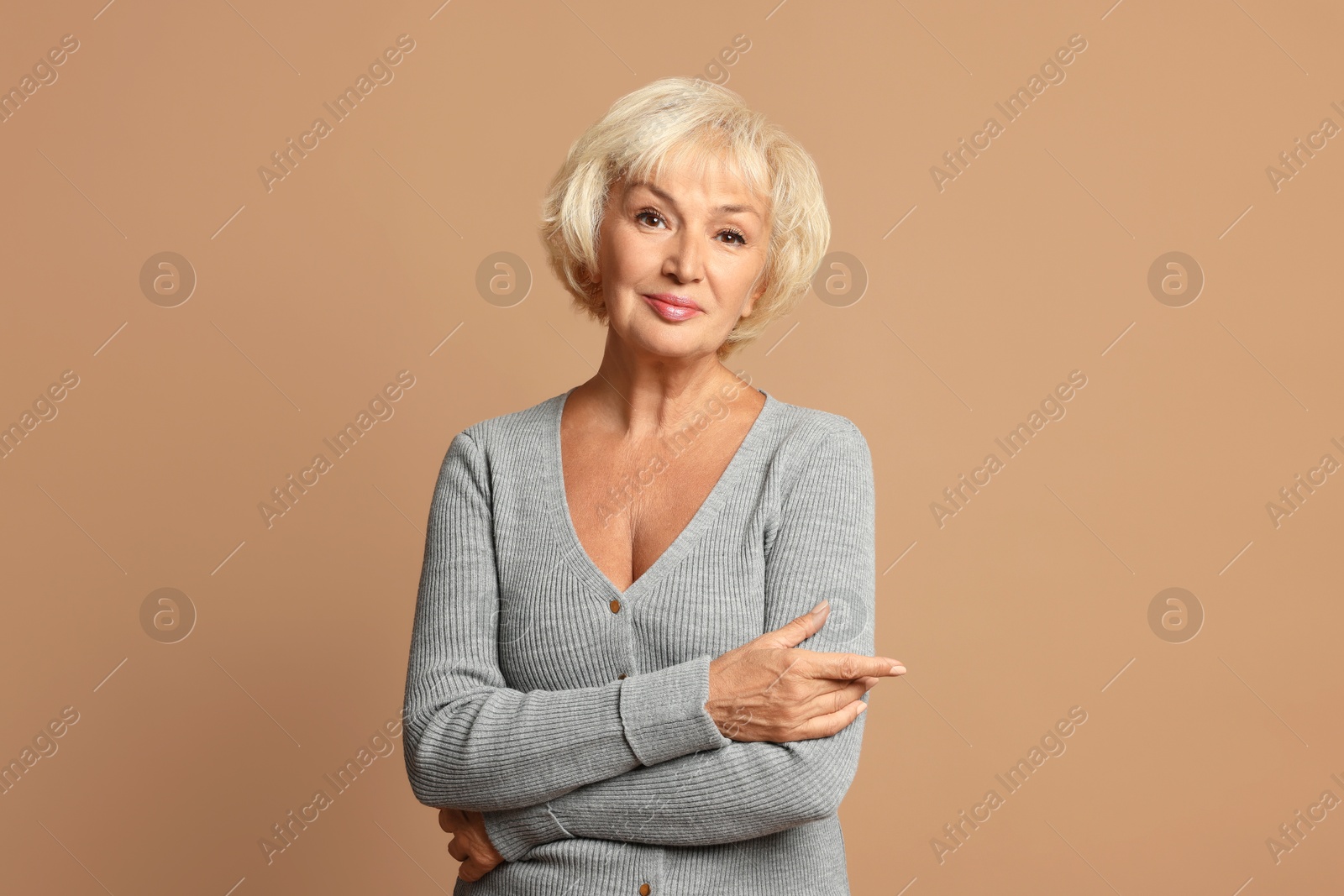 Photo of Portrait of beautiful senior woman on light brown background