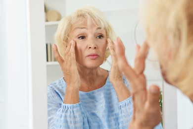 Photo of Beautiful senior woman near mirror at home