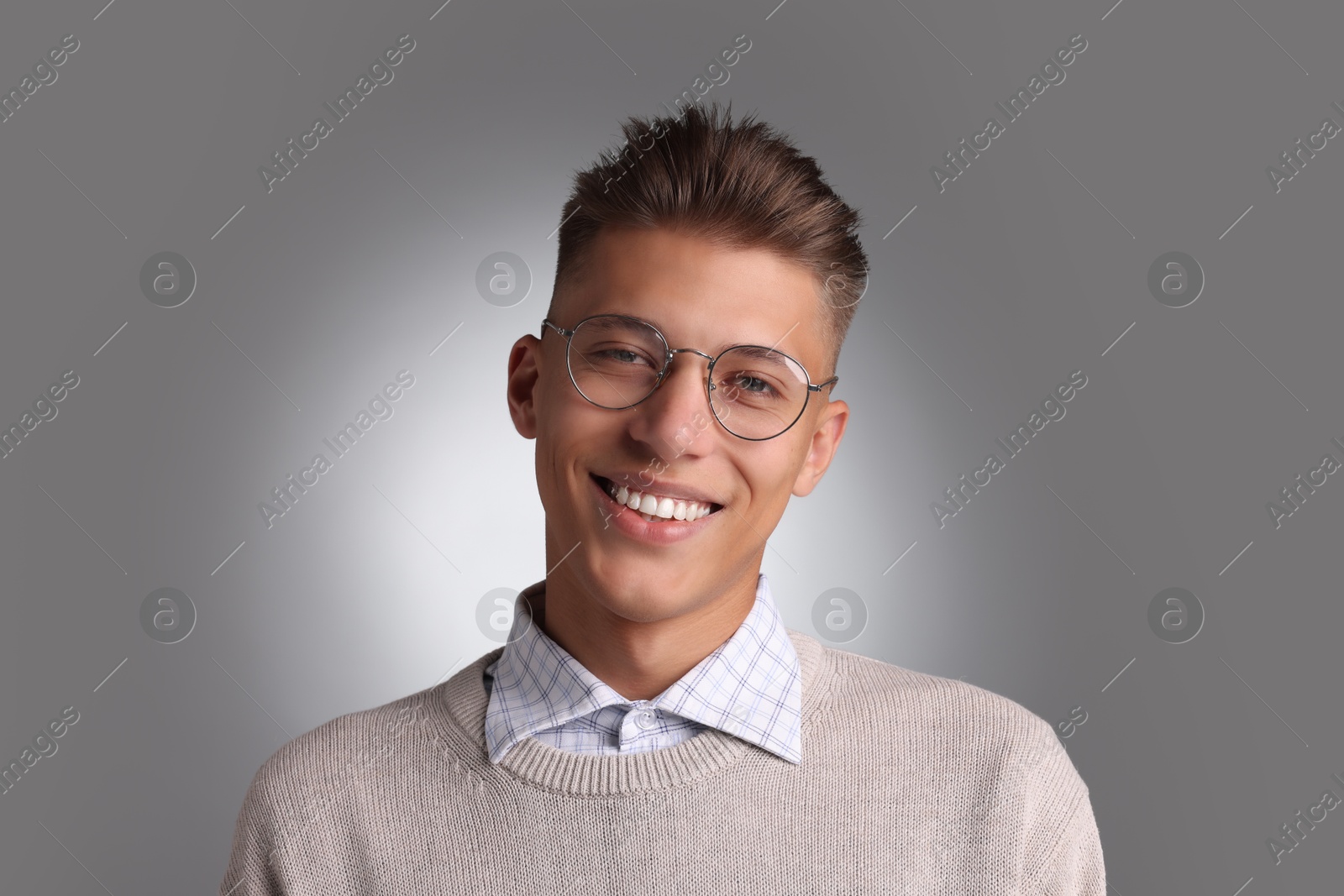 Photo of Handsome young man with stylish haircut on grey background