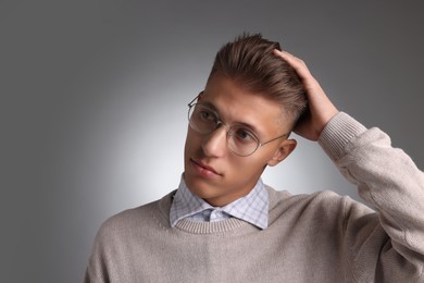 Photo of Handsome young man with stylish haircut on grey background