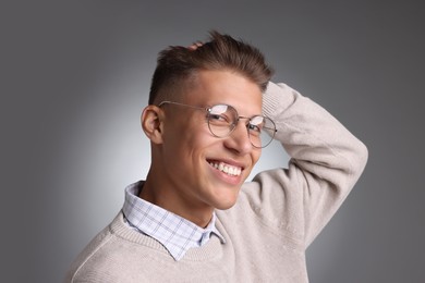 Photo of Handsome young man with stylish haircut on grey background