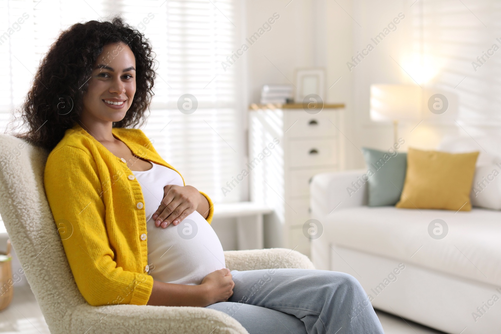 Photo of Portrait of beautiful pregnant woman in armchair at home