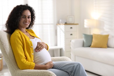 Photo of Portrait of beautiful pregnant woman in armchair at home