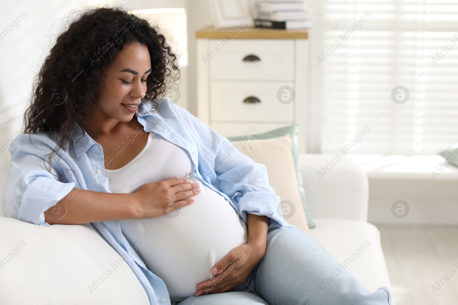 Photo of Portrait of beautiful pregnant woman on sofa at home