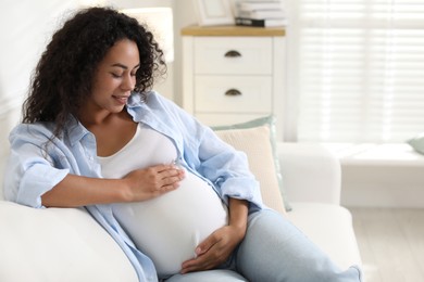 Photo of Portrait of beautiful pregnant woman on sofa at home