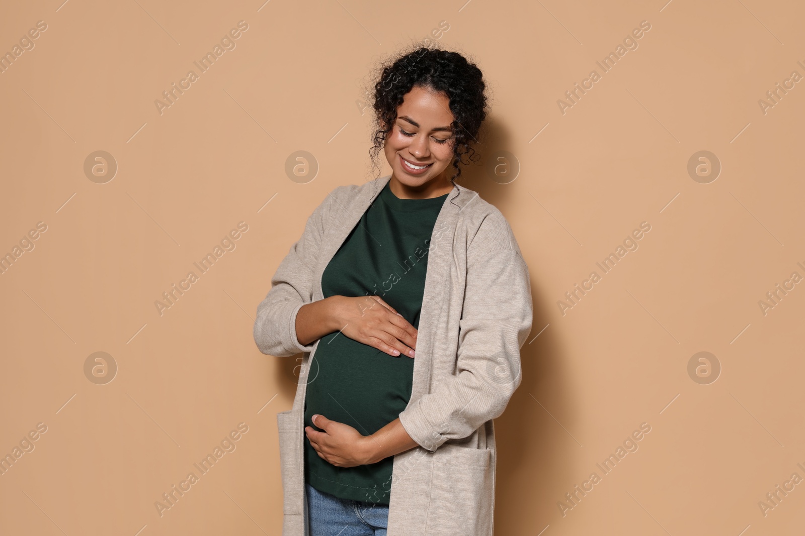 Photo of Portrait of beautiful pregnant woman on beige background