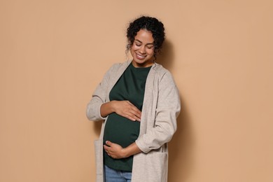 Portrait of beautiful pregnant woman on beige background