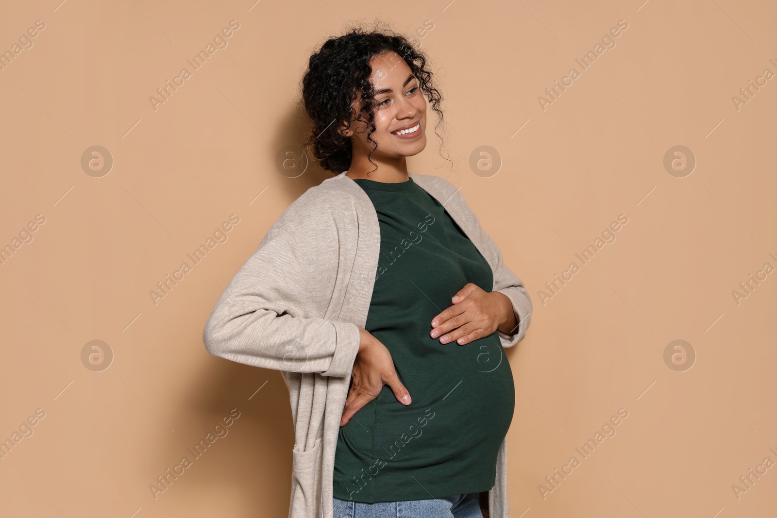 Photo of Portrait of beautiful pregnant woman on beige background