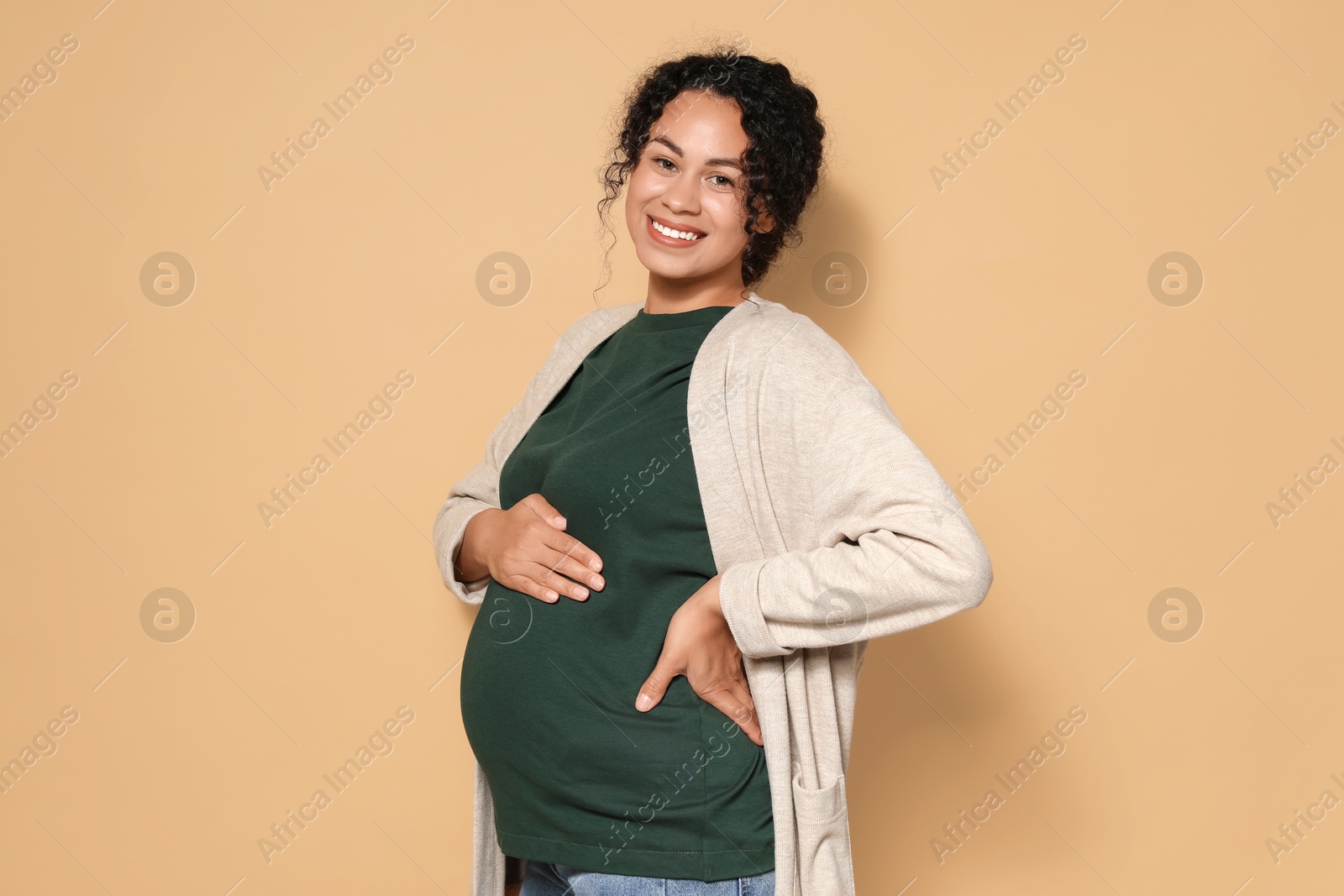 Photo of Portrait of beautiful pregnant woman on beige background