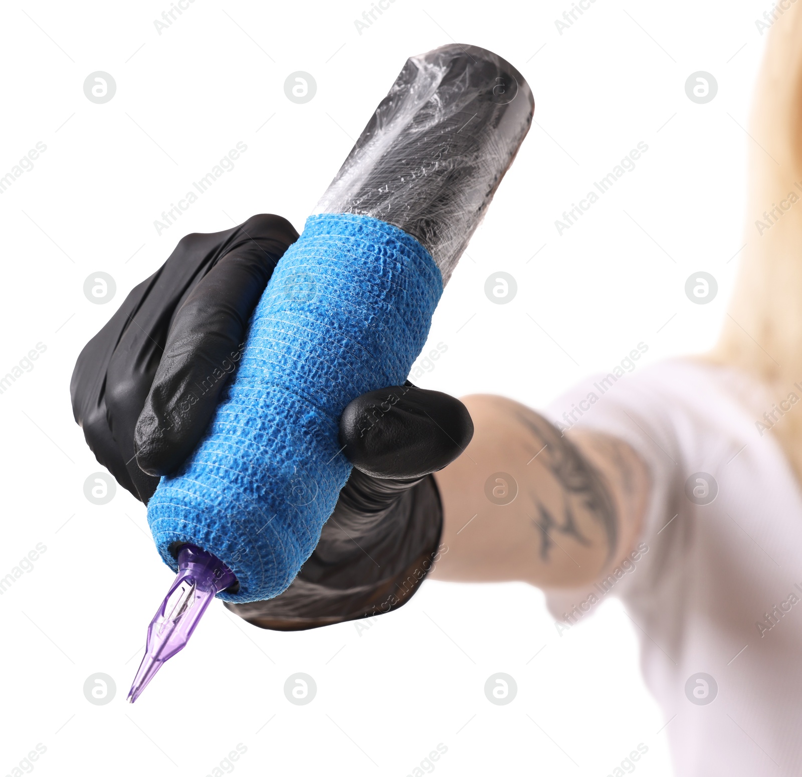 Photo of Professional artist in gloves holding tattoo machine on white background, closeup