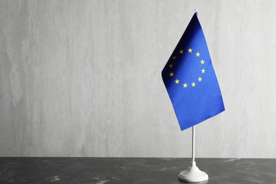 Photo of One flag of European Union on grey marble table. Space for text