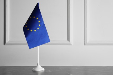 Photo of One flag of European Union on grey marble table. Space for text