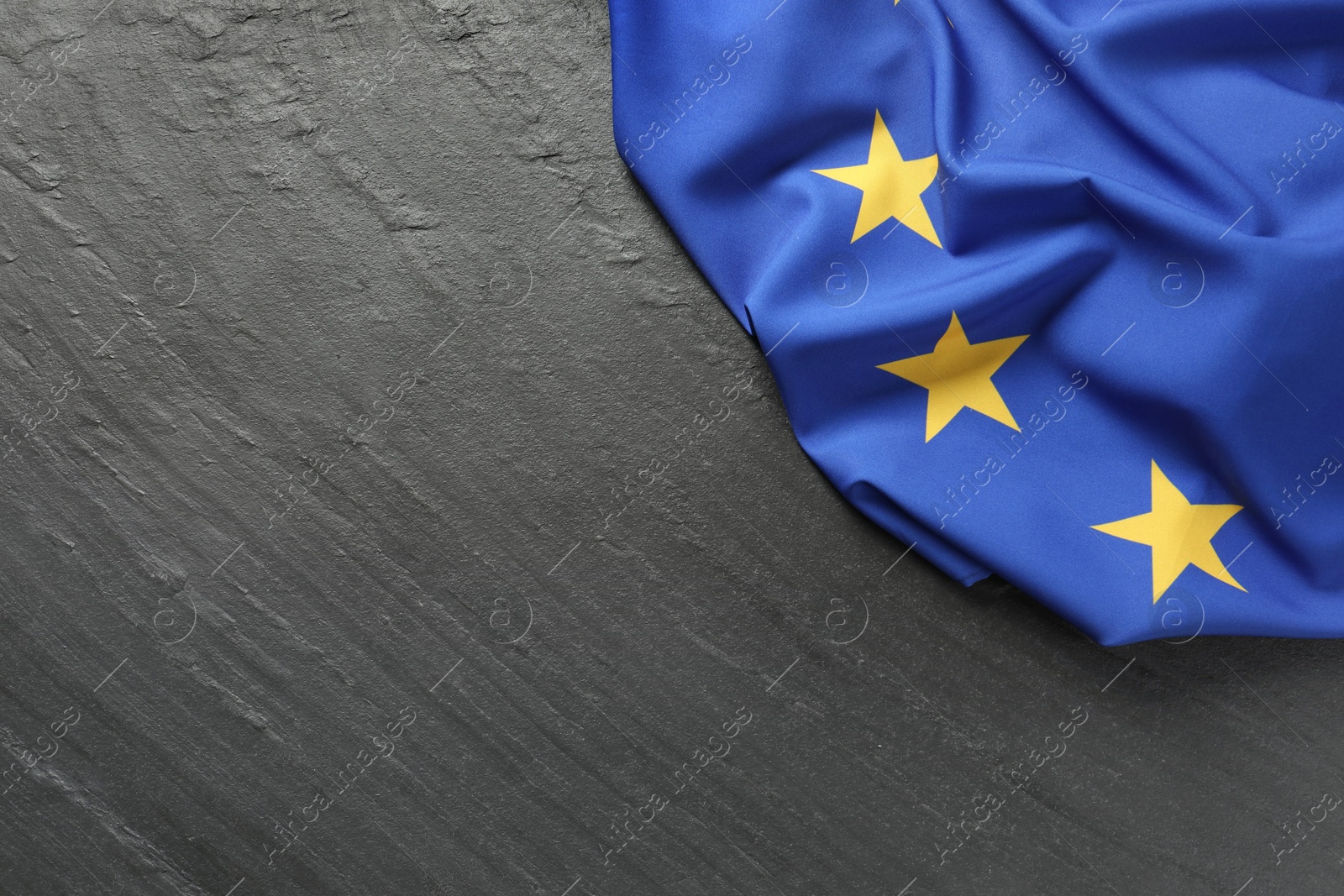 Photo of Flag of European Union on black textured background, top view. Space for text