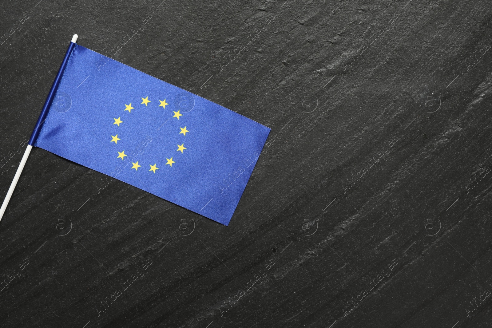 Photo of Flag of European Union on black textured background, top view. Space for text