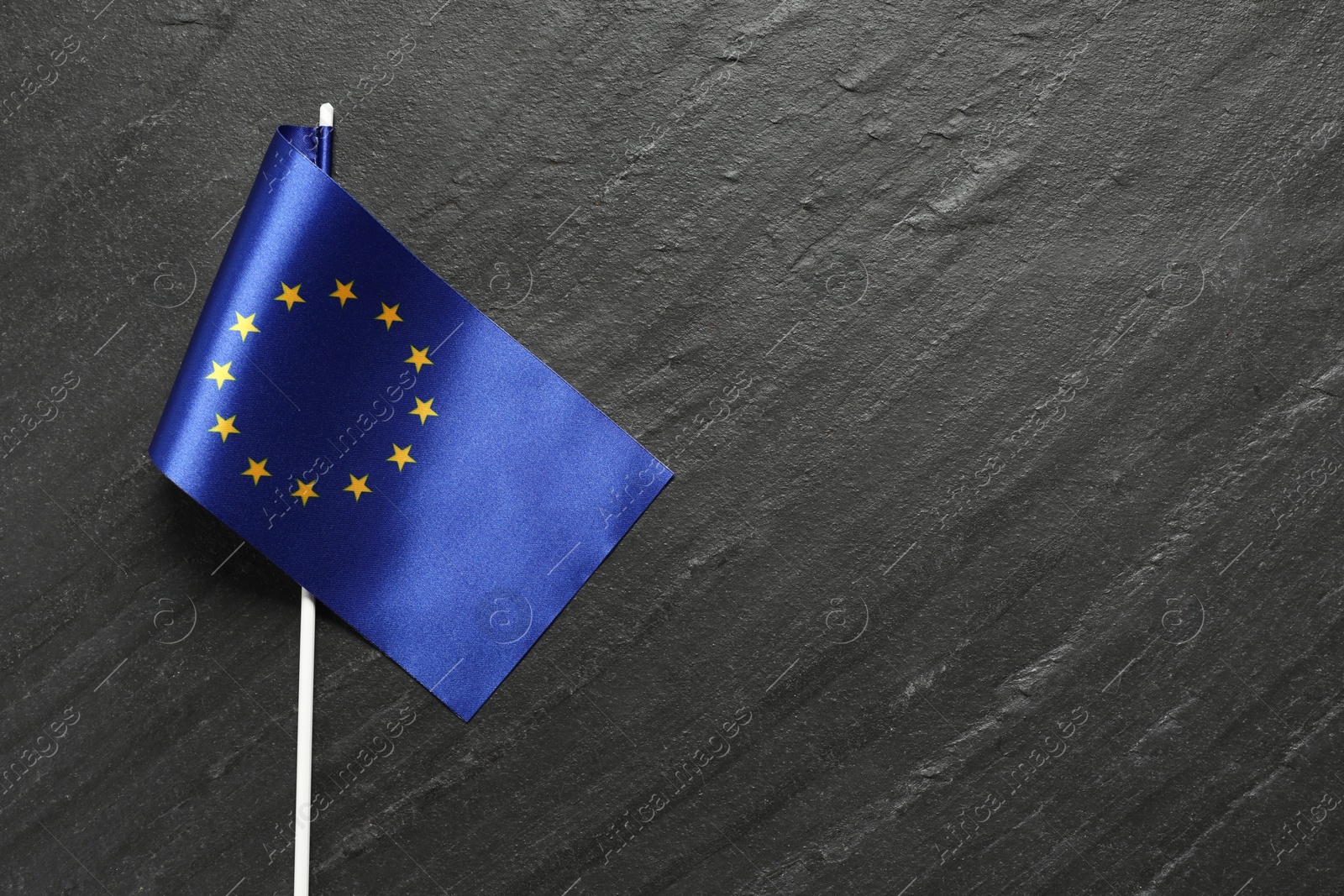 Photo of Flag of European Union on black textured background, top view. Space for text