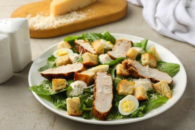 Photo of Tasty Caesar salad with chicken on light grey table