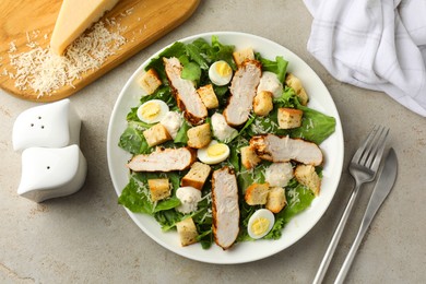 Photo of Tasty Caesar salad with chicken on light grey table, flat lay