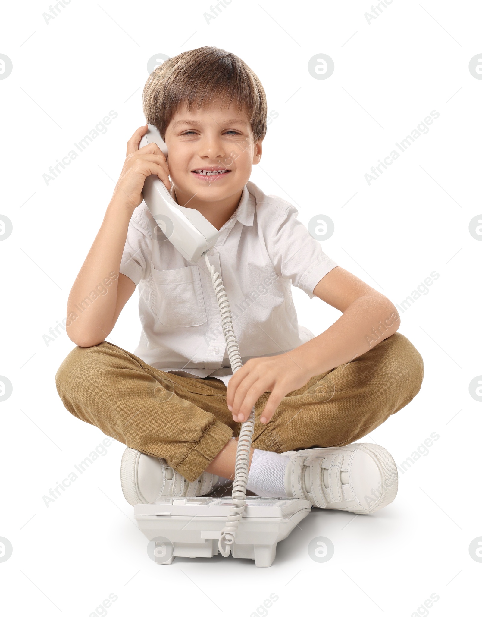 Photo of Cute little boy with telephone on white background